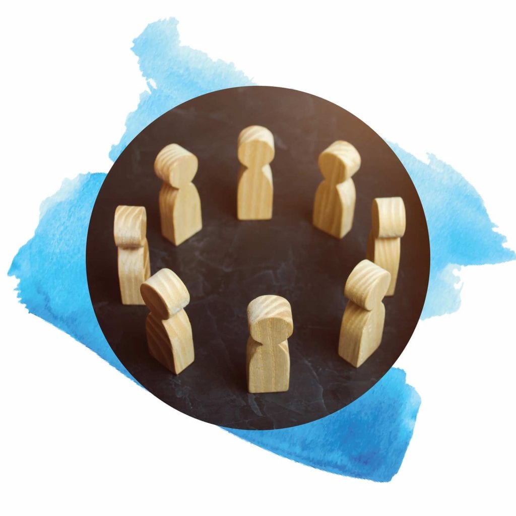 Close shot of a circle of simple wooden people.